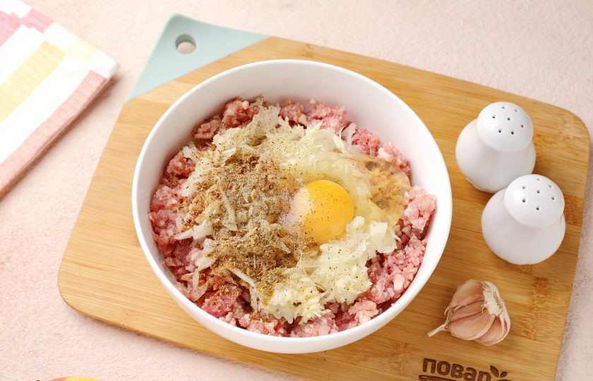 1. Этап. Запеканка из фарша с яблоками: Фарш переложите в глубокую миску. Добавьте тёртый на крупной тёрке лук, яйцо, соль и специи по вкусу.