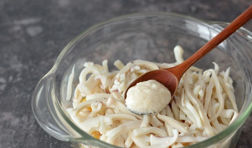 1. Этап. Салат с кальмарами, яблоком и кукурузой: Посолите по вкусу салат и обязательно добавьте ложечку столового хрена для пикантности.