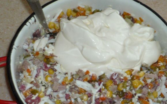 1. Этап. Салат Оливье с копченой колбасой: Нарезаем все подготовленные ингредиенты кубиками среднего размера. Складываем в миску или салатницу. Солим по вкусу и заправляем майонезом. Тщательно перемешиваем.