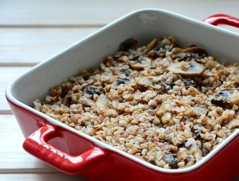 1. Этап. Гречка с курицей: Отварную гречку перемешайте с лучком и грибочками. Возьмите форму для запекания, в которой планируете готовить блюдо. Выложите в нее гречку с грибами.