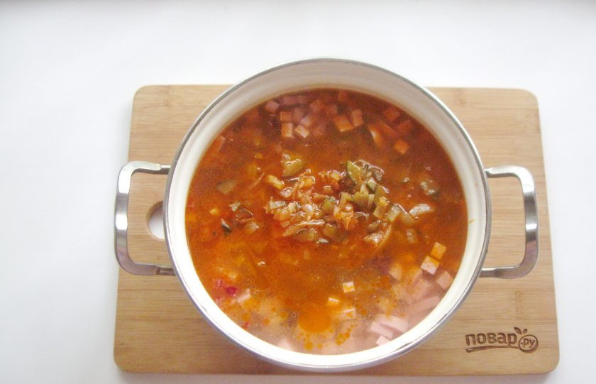 1. Этап. Солянка с солеными грибами: Выложите лук с огурцами и томатной пастой.