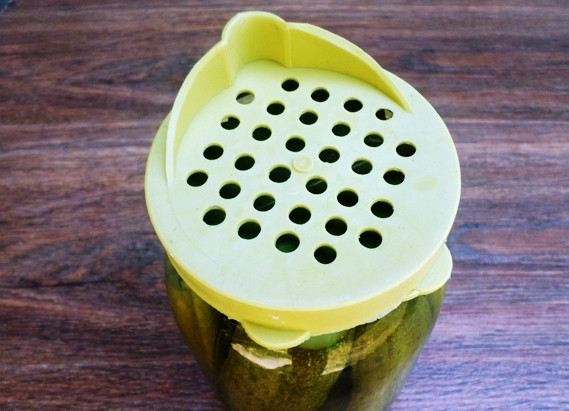 1. Этап. Огурчики с кетчупом на зиму: Через 10 минут слейте воду из банки обратно в кастрюлю, можете воспользоваться для этого капроновой крышкой. Не страшно, если семена горчицы попадут в кастрюлю.