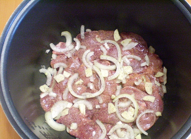 1. Этап. Куриная печень в сметане в мультиварке: Промойте тщательно печень куриную под проточной водой, чтобы стекла лишняя кровь. На дно кастрюлю положите часть лука, чеснока, потом печень и снова лук и чеснок. Добавьте специй и соли по вкусу.