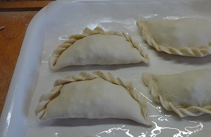 1. Этап. Слоеные пирожки с мясом Эмпанадас: Духовку разогреть до 200 градусов, выложить пирожки на противень, смазать молоком.