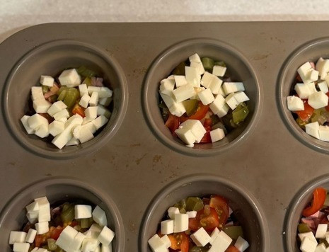 1. Этап. Закусочные маффины из яиц: Сверху в формочки выложить сыр, нарезанный мелким кубиком