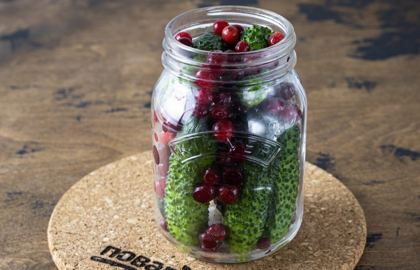 1. Этап. Огурцы с медом и клюквой: Затем промойте их и выложите в чистую стерилизованную банку. Промежутки заполните клюквой.