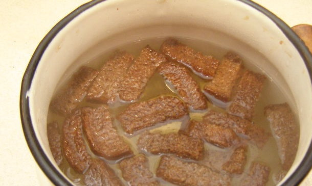 1. Этап. Квас из черного хлеба: Заливаем сухари кипятком и накрываем салфеткой на 4 часа. Добавляем сахар и дрожжи, оставляем бродить в теплом месте.