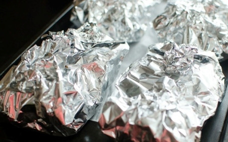 1. Этап. Куриные бедрышки в фольге: Плотно заворачиваем каждую порцию мяса с картошкой в фольгу, выкладываем их на противень. Отправляем в разогретую до 180 градусов духовку на 40-50 минут.