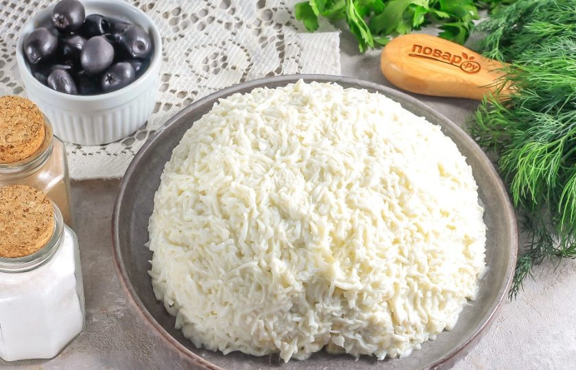 1. Этап. Салат с ананасами на Новый год Кролика 2023: Выложите натертые белки на салат, слегка прижимая их к нему.