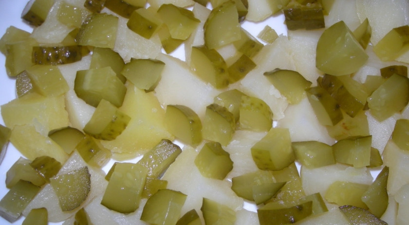 1. Этап. Салат Печень трески: 1. Итак, для начала отварим картофель и яйца. Затем нарезаем картофель кубиками и выкладываем его первым слоем. Далее — нарезанные произвольно солёные огурцы.