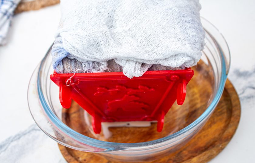 1. Этап. Творожно-шоколадная пасха заварная: Прикройте отвисшими краями марли. Поставьте пасочницу в глубокую миску. Сверху установите груз (например банка огурцов или ананасов). Уберите в холодильник на 10-12 часов.