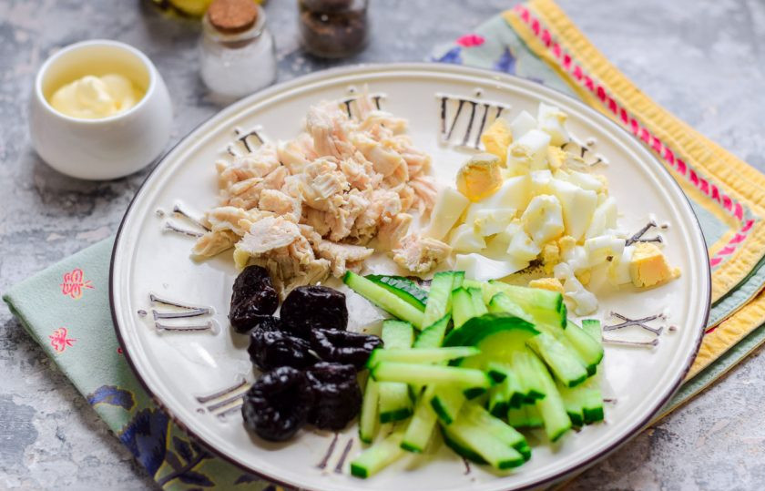 1. Этап. Салат Дамский каприз с курицей и черносливом: Филе курицы отварите заранее, после разберите на волокна. Куриное яйцо отварите в течение 10 минут, почистите от скорлупы, нарежьте небольшими кусочками. Огурец сполосните, нарежьте полосками. Также нарежьте чернослив.