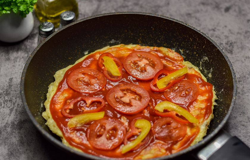 1. Этап. Быстрая пицца на сковороде из лаваша с яйцом: Выложите кусочки перца и помидоров поверх основы.