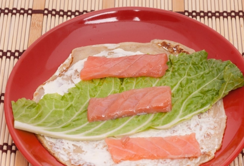 1. Этап. Блины с семгой и творожным сыром: 2. Каждый блин смажем сыром, выкладываем кусочек капустного листа и немного рыбы. Сворачиваем рулетом.