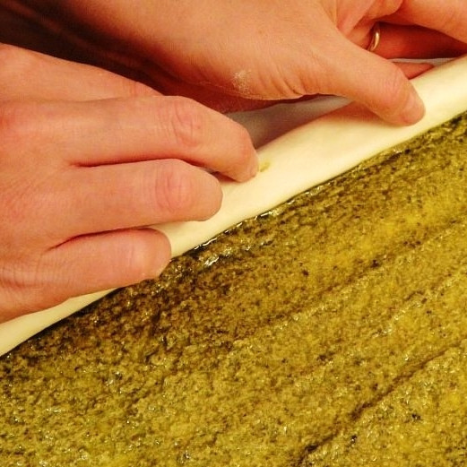 1. Этап. Печенье слоеное: Начинаем сворачивать наше тесто с начинкой по длинному краю в рулет. Сворачиваем до середины теста и останавливаемся.