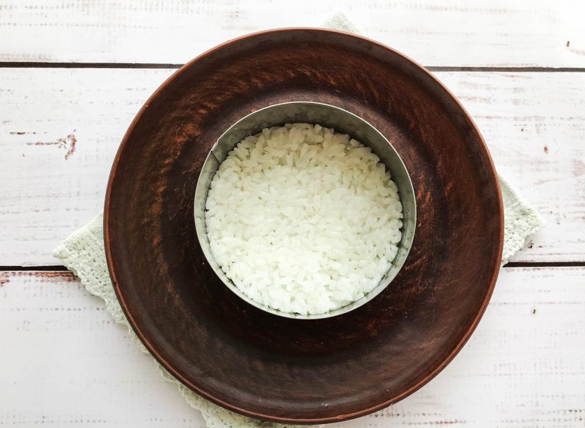 1. Этап. Салат Диана с печенью трески: На тарелку выложите сервировочное кольцо. Нижний слой сделайте из риса. Рис смешайте с маслом печени трески.