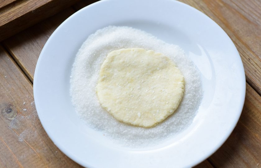 1. Этап. Шаники: Каждую часть творожного теста раскатайте в блинчик и выложите одной стороной в сахар на тарелке.