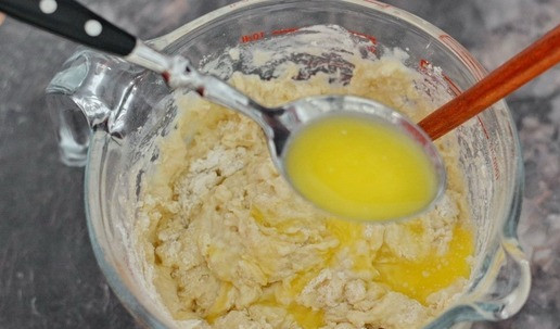 1. Этап. Сдобный калач на сливках: Начните замешивать тесто в рабочей ёмкости при помощи лопаточки. Растопите сливочное масло и в процессе замеса добавьте его в тесто.