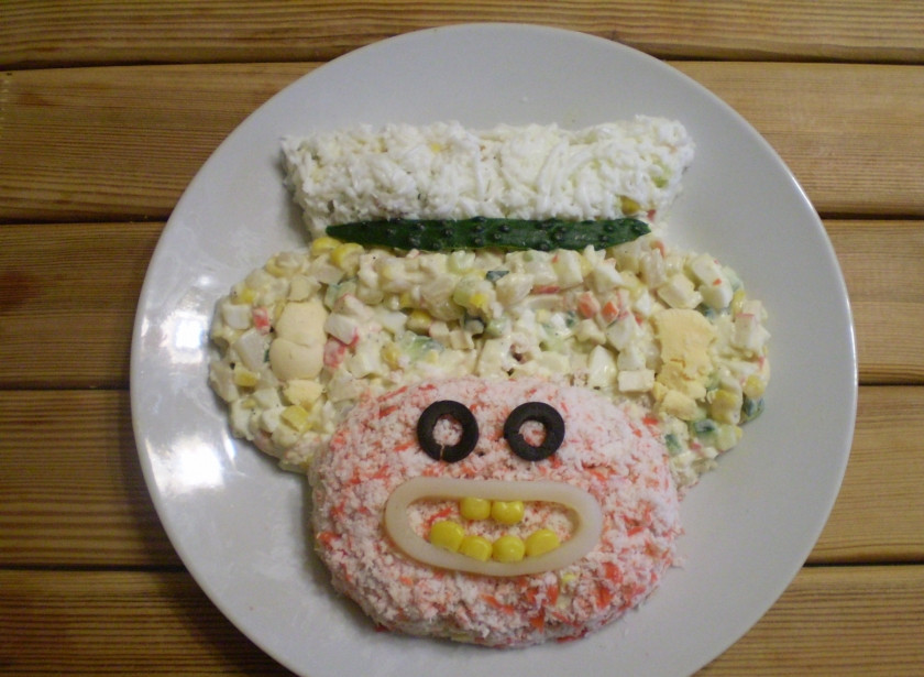 1. Этап. Салат Обезьянка с кальмарами: Шапочку сделайте из белка и полоски огурца. Вставьте 