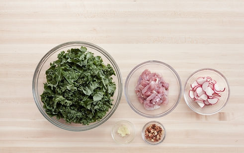 1. Этап. Салат с курицей и редиской: 1. Капустные листья снимаю со стебля и мою, затем нарезаю крупными кусками. Курицу мою и удаляю кости, затем нарезаю полосками. Редис мою и нарезаю тонкими кольцами или полукольцами. Чеснок чищу и пропускаю через пресс. Миндаль нарезаю крупно и обжариваю на сухой сковороде.