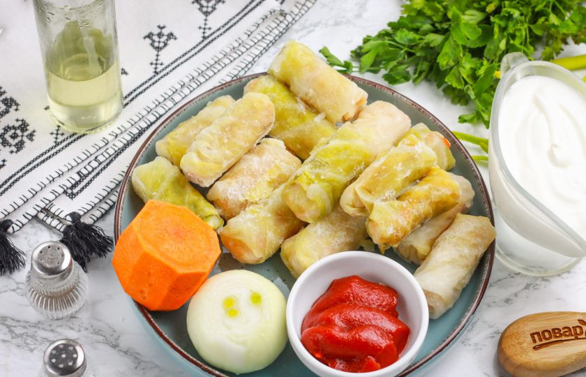 1. Этап. Замороженные голубцы на сковороде: Подготовьте указанные ингредиенты. Замороженные голубцы слегка разморозьте буквально за 20 минут до начала приготовления. Лук и морковь очистите и промойте в воде.