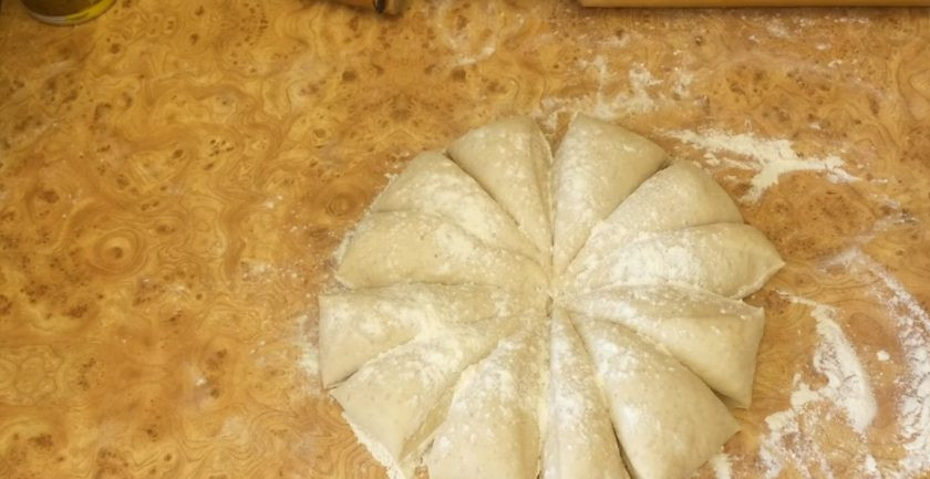 1. Этап. Булочки к чаю сдобные: 4. Выложите тесто на рабочую поверхность, присыпанную мукой, и округлите. Разделите тесто на две части, одну из них накрыв пленкой. Разделите часть теста на 12 частей и округлите.