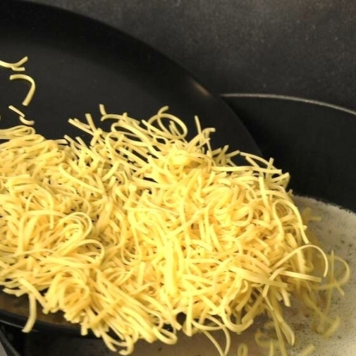 1. Этап. Чесночный крем-суп: Спустя оговоренные 20 минут добавляем в кастрюлю немного мелкой лапши. Перемешиваем и варим до готовности лапши.