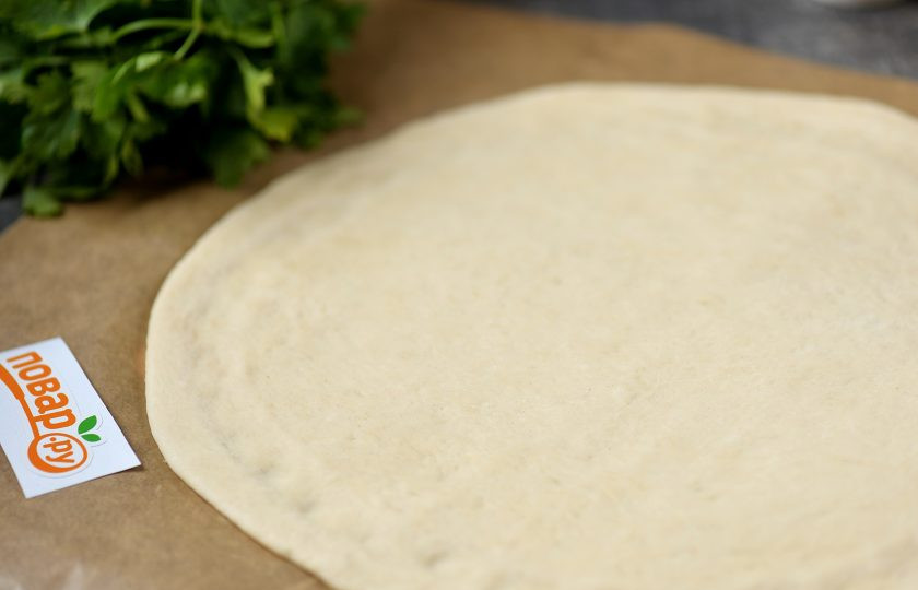 1. Этап. Пицца с горгонзолой: При необходимости присыпьте пергамент мукой, раскатайте тесто тонко, придайте круглую форму, хотя толщину регулируйте по своему желанию.