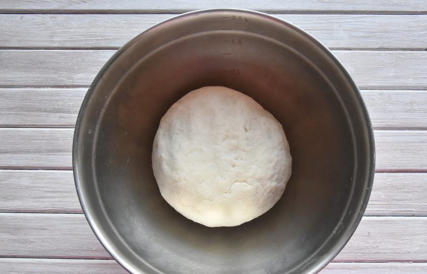 1. Этап. Момо с курицей: Когда вся мука впитает в себя влагу, переложите заготовку на столелешницу и продолжите замес. Тесто должно получится достаточно упругим. Округлите заготовку, выложите ее в миску, накройте кухонным полотенцем и оставьте отдохнуть.
