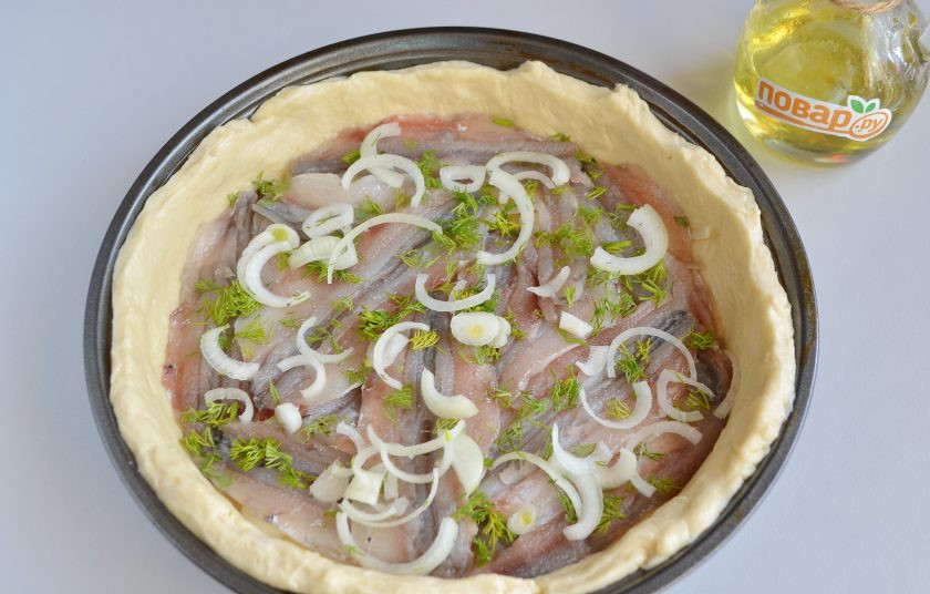 1. Этап. Пирог с мойвой и укропом: 7. Готовое тесто разделите на две части. Первую часть раскатайте не очень тонко, положите в смазанную форму, лишние края обрежьте. На тесто положите слой лука, потом слой рыбы, соль-перец, укроп, снова лук, рыба, укроп и т.д.