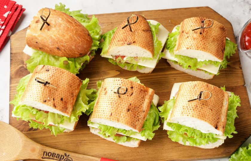 1. Этап. Праздничные бутерброды Змейка: Смажьте верхнюю часть багета соусом и аккуратно накройте начинку сверху. Для фиксации можно использовать шпажки.