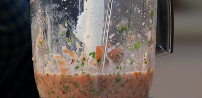 1. Этап. Куриная грудка в беконе: Пока сделайте соус. Помидоры помойте, удалите плодоножки, нарежьте. Кинзу промойте и измельчите. Половинку луковицы нарежьте. Ингредиенты измельчите в блендере, добавив сок половины лимона, немного масла и соль.