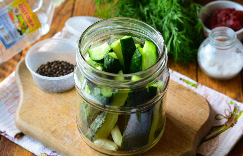 1. Этап. Огурцы в томатной пасте на зиму: Нарежьте огурцы средними полосками, чтобы легче было укладывать в банки. Сложите огурцы в простерилизованные баночки.