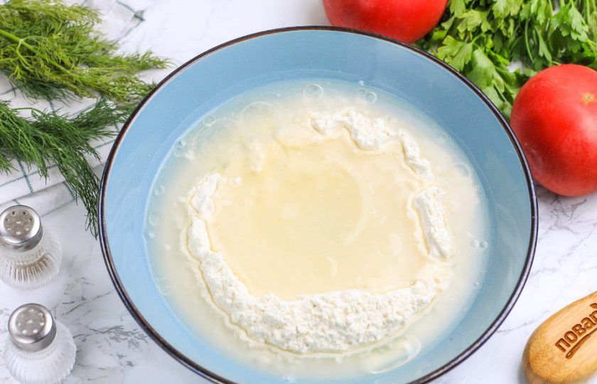 1. Этап. Быстрая пицца: В глубокую емкость всыпьте пшеничную муку высшего сорта, сделайте в ней лунку. Всыпьте туда соль и влейте горячую воду, растительное масло. По желанию можно добавить в тесто различные специи и пряности. Начните перемешивать тесто вилкой, а затем руками, когда оно немного остынет.