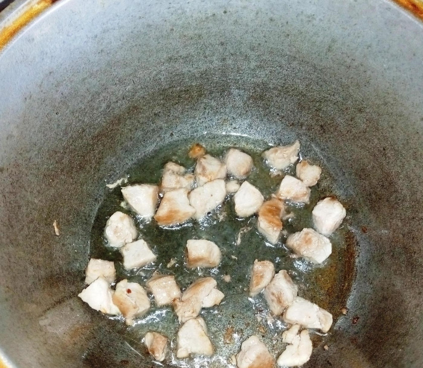 1. Этап. Жаркое по-домашнему из свинины с картошкой: 1. Мякоть свинины мою и измельчаю кубиком. Казан отправляю на огонь, наливаю растительное масло и разогреваю, затем выкладываю мясо в казан и обжариваю.