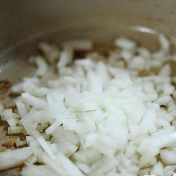 1. Этап. Рёбрышки в томатном соусе: Поместите в утятницу лук и чеснок, хорошенько перемешайте и готовьте около минуты.