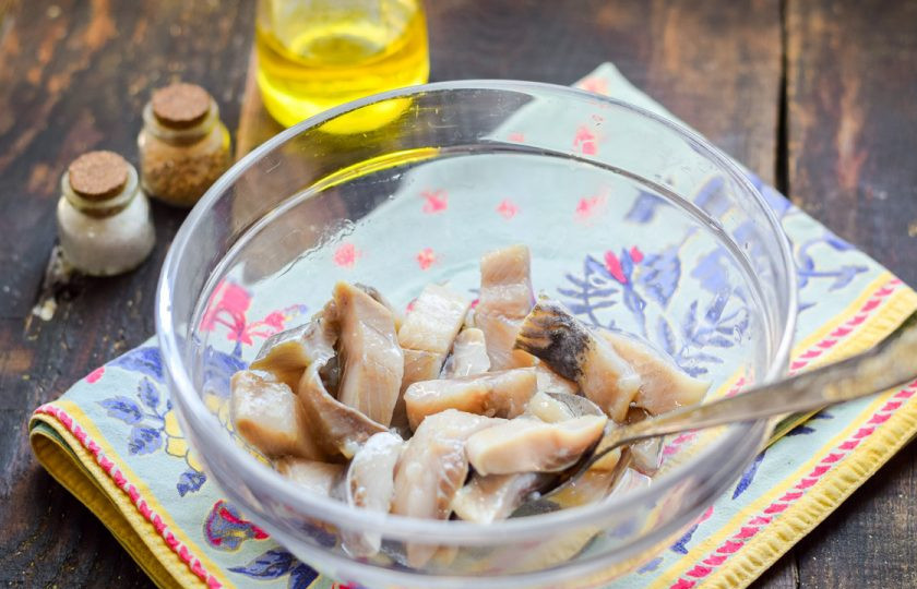 1. Этап. Селедка с картошкой в духовке: Переложите сельдь в глубокую миску, добавьте масло.