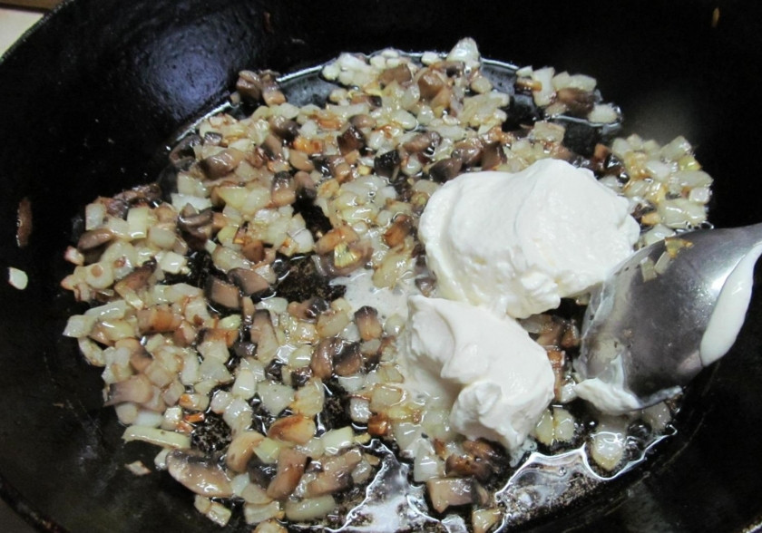 1. Этап. Картошка, фаршированная шампиньонами: На разогретую сковороду положите сливочное масло, затем — грибы. Жарьте примерно минут 5. Затем добавьте к грибам лук, жарьте 3 минуты, добавьте сметану. Перемешайте и готовьте еще примерно 5 минут на медленном огне, постоянно помешивая. Подготовьте картофель. Порежьте его вдоль, ложкой удалите середину, чистить его не обязательно.