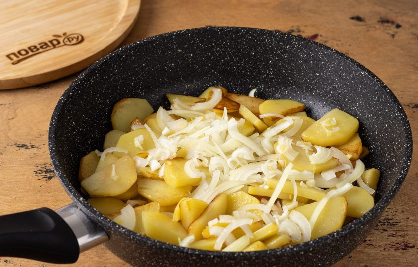 1. Этап. Жареная картошка с луком: Спустя 5-6 минут добавьте нарезанный полукольцами репчатый лук. Дайте немного пропариться луку сверху, затем перемешайте.