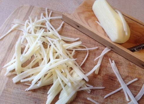 1. Этап. Глухариное гнездо: Очистим картофелину среднего размера, помоем и обсушим. А затем нарежем на тонкие полоски с помощью терки для корейской морковки.
