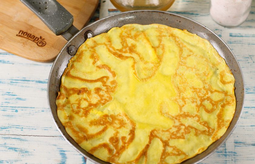 1. Этап. Блины на пахте: Затем прогрейте блинную сковороду на плите, включая умеренный нагрев. Смажьте ее первый раз растительным маслом и влейте половником порцию теста. Обжарьте блин с каждой стороны по 1-2 минуте до румяности.