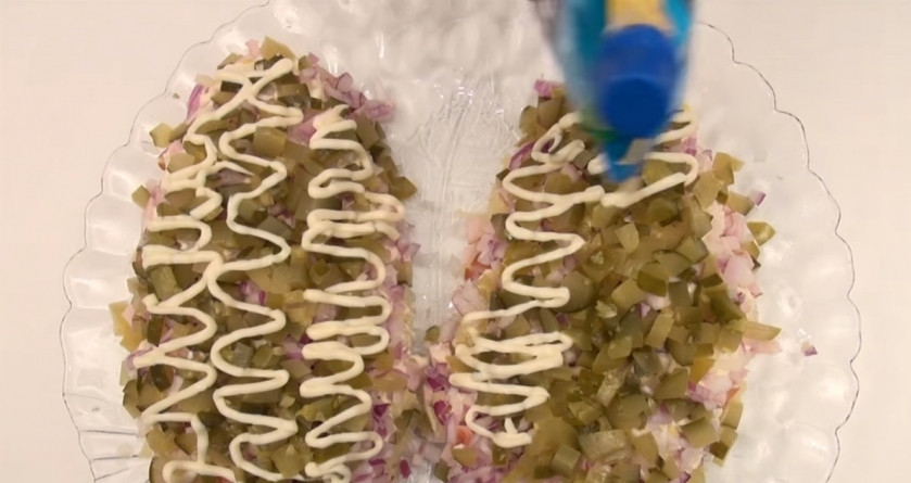 1. Этап. Салат Еловые шишки: 5. Посыпаем всё измельчёнными огурчиками и смазываем майонезом.