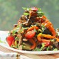 Салат с баклажанами как основное блюдо Мясо нарезать тонкими, длинными полосочками. Добавить соевый соус, терияки, 3 ст. л. растительного масла, чеснок, порезанный очень тоненько пластинками, перемешать и убрать на 30 минут. Баклажаны нарезать пластинами вдоль, толщиной не менее 0.5 см. Чуть присолить и поставить в СВЧ на 4 минуты. Таким образом баклажаны не впитают при обжарке много масла. После сигнала достать и обсушить. У меня был свежемороженный перец и свежий. Свежий порезать длинными полосками. Выкладываем на разогретую с 1 ст. л. масла сковороду мороженый перец и обжариваем минуту на сильном огне. Всыпаем свежий перец, добавляем сахар и обжариваем на сильном огне пару минут - перец не должен стать очень мягким. Выкладываем перец в емкость (масло после обжаривания оставляем на сковороде), на перец нарезаем кубиками помидор - у меня были черри. Обжариваем до зарумянивания с двух сторон баклажаны. Если необходимо, добавьте еще 1 ст. л. масла. Баклажаны режем на крупные кусочки поперек И выкладываем к перцу. Мясо вместе с маринадом обжариваем на сильном огне около 5 минут - жидкость должна полностью выпариться. Сковорода должна быть большого диаметра или обжаривайте порциями - мясо не должно тушиться! Добавляем мясо к овощам. Добавляем колечки чили и нарезанную зелень - у меня кинза. Перемешиваем и выкладываем в салатник и посыпаем орехами. Я орехи не добавляла.