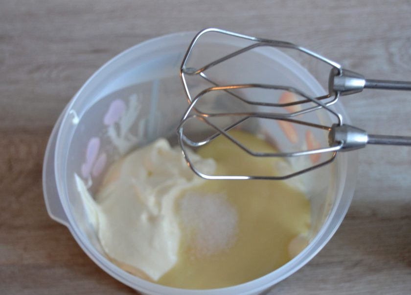 1. Этап. Морковный торт с вишней: Для приготовления сметанного крема взбейте сметану и сгущенное молоко, они должны быть охлажденными, из холодильника. Добавьте в массу ванильный сахар.