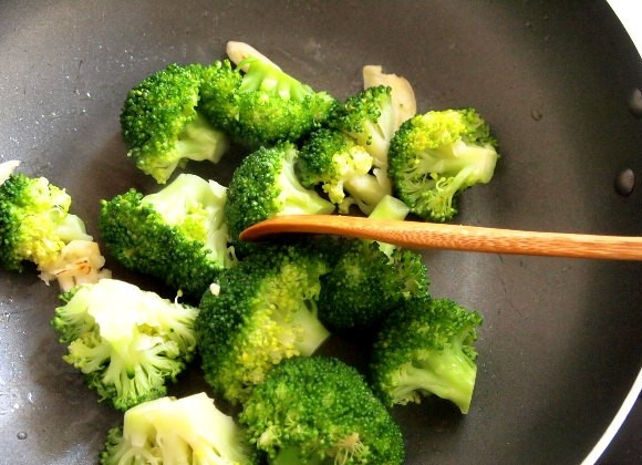 1. Этап. Брокколи с морепродуктами: В сковороду налейте растительное масло, хорошо разогрейте его. Выложите в сковороду соцветия капусты, посолите и на большом огне обжарьте их втечение 1-2 минут, выложите их из сковороды. По желанию можно насыпать на капусту немного натёртого пармезана.