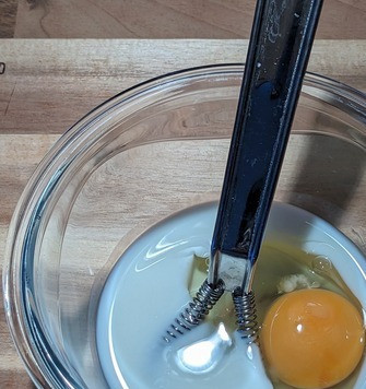 1. Этап. Булочка из отрубей в микроволновке: Влить в чашку кефир, добавить яйцо и размешать до однородности.