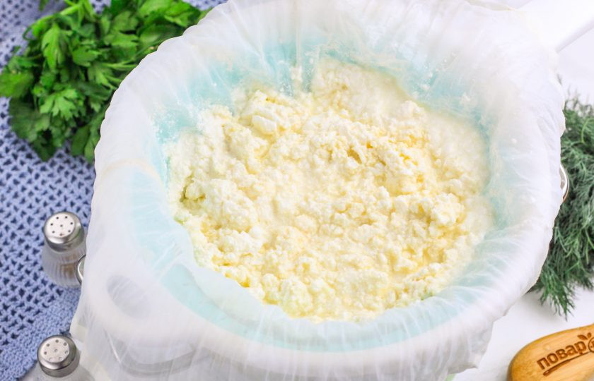 1. Этап. Адыгейский сыр на кефире: Перелейте содержимое емкости в дуршлаг, застеленный двойным слоем марли или специальной тканью для приготовления сыра, творога. Дайте стечь сыворотке и вмешайте в массу соль. По желанию можно добавить тмин, измельченную зелень, кусочки вяленых томатов и т.д. — по вашему вкусу. Если кефир не жирный, то растопите и влейте в массу сливочное масло. Затем соберите края марли или ткани и завяжите, чтобы получился колобок. Подвесьте сыр над раковиной на 1-2 часа, чтобы стекла лишняя сыворотка.