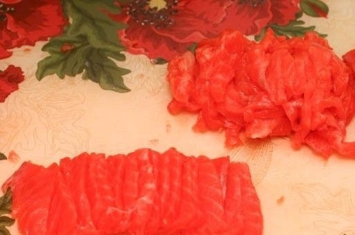 1. Этап. Салат с красной рыбой слоями: 4. Рыбку нарежьте тонкими пластинками. Наиболее ровные кусочки отложите в сторону и оставьте для украшения салата.