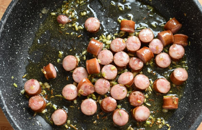 1. Этап. Паста с колбасками, маслинами и пряными травами: Добавьте нарезанные толстыми кружочками охотничьи колбаски и немного обжарьте их.