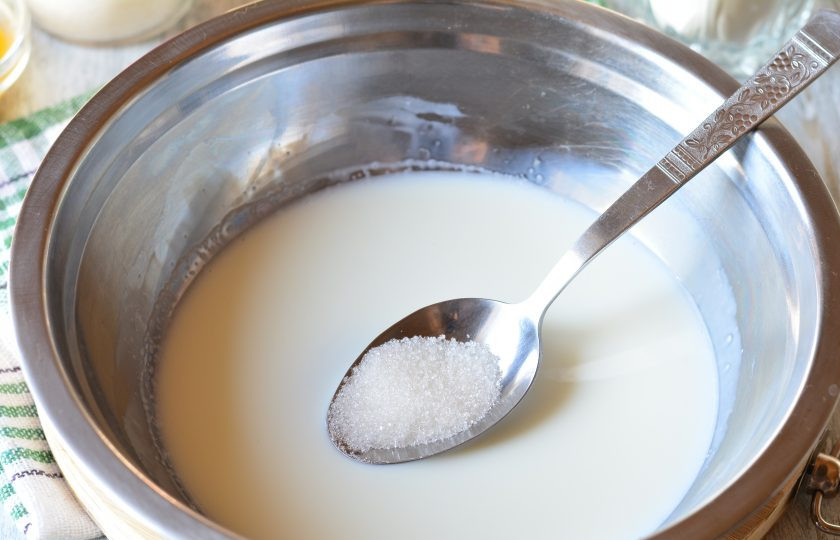 1. Этап. Пышный кулич: Приготовьте опару. В теплое молоко всыпьте 1 столовую ложку сахара.